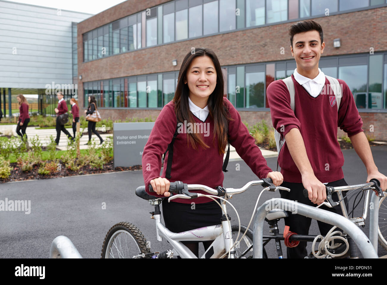 Teenager-Freunde mit Zyklen außerhalb der Schule Stockfoto