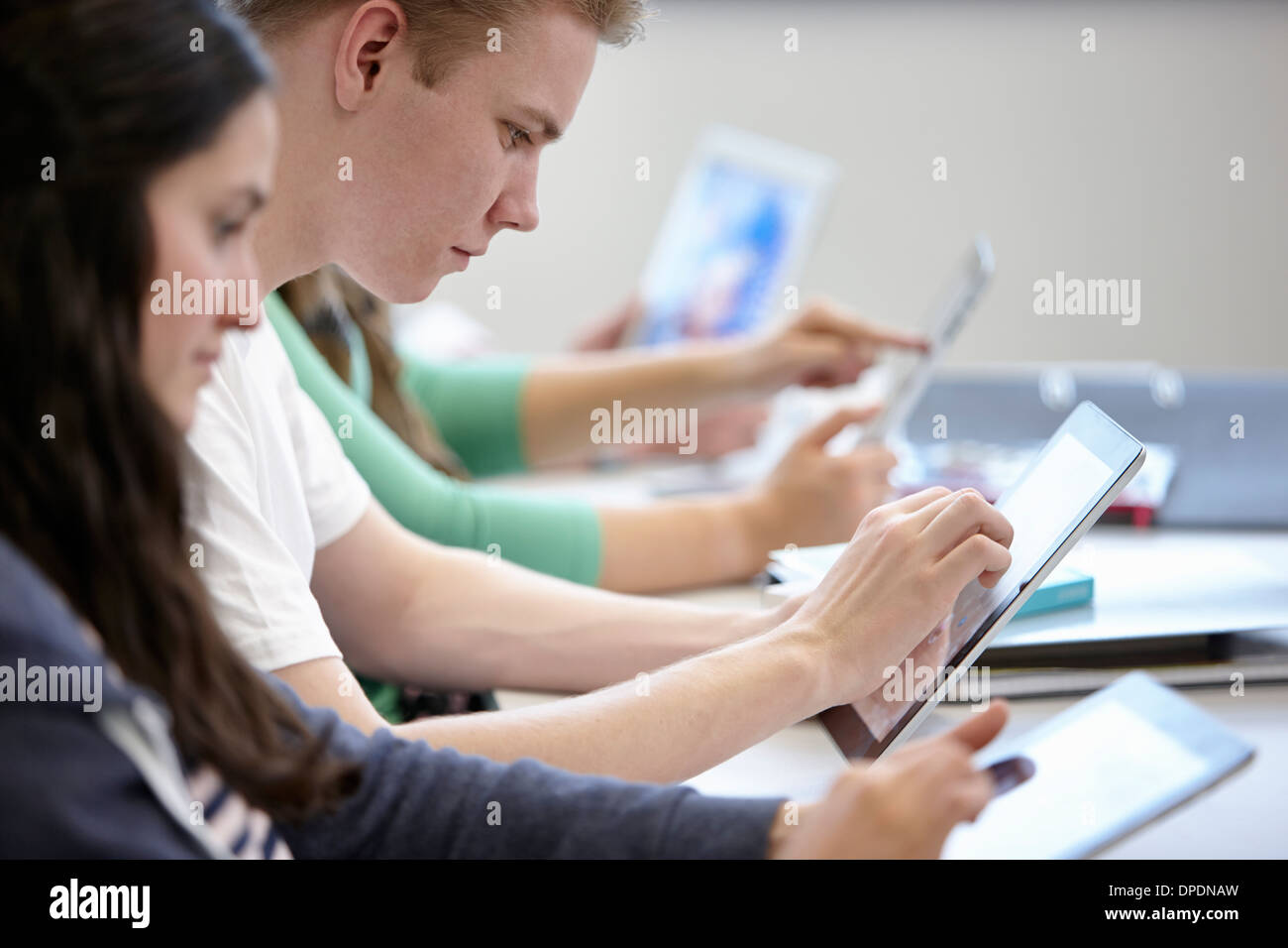 Jugendliche, die mit digitalen Brettchen Klassenzimmer Stockfoto