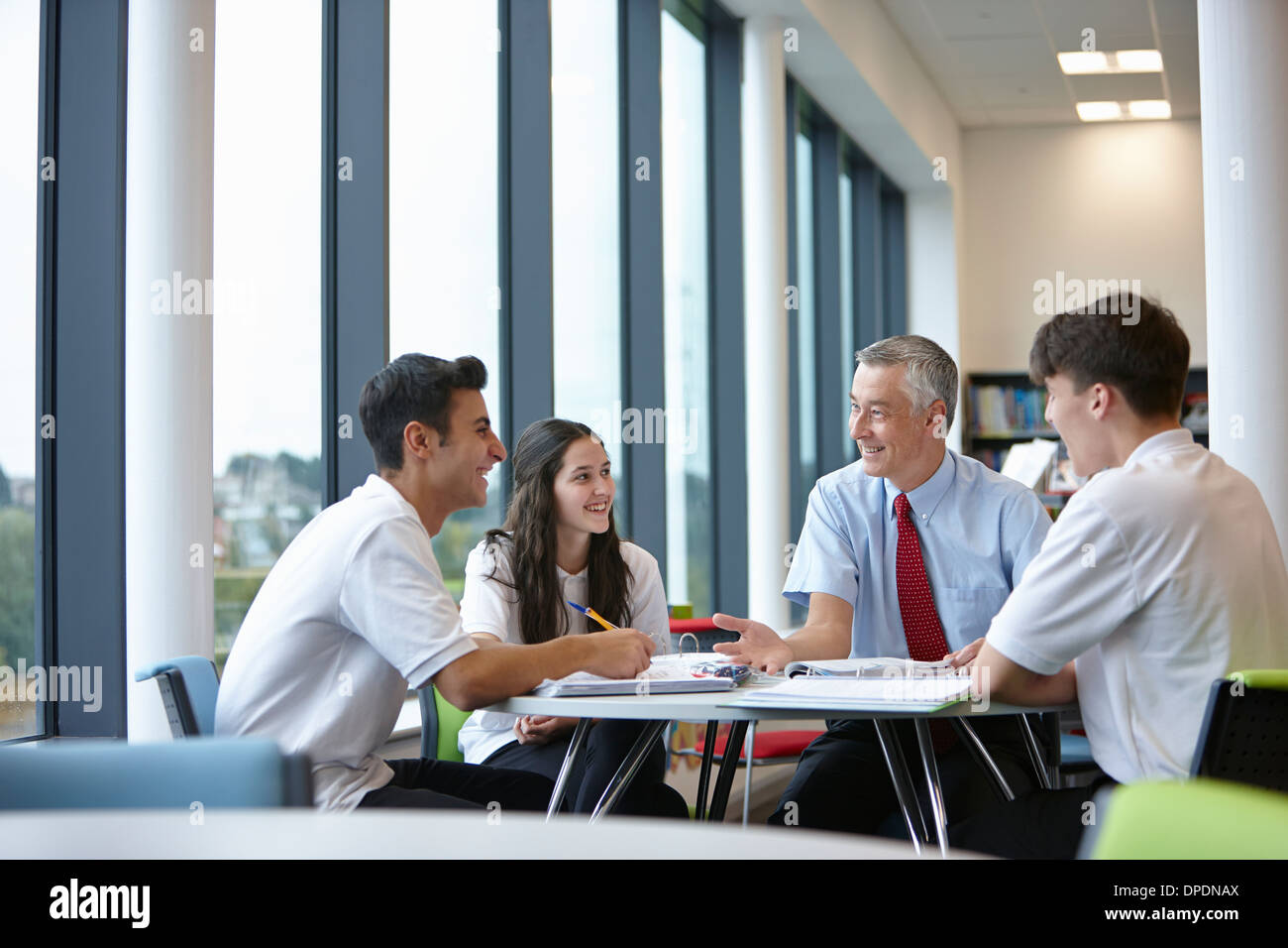 Gruppe von Jugendlichen, die Arbeit mit Lehrer in der Schulklasse Stockfoto