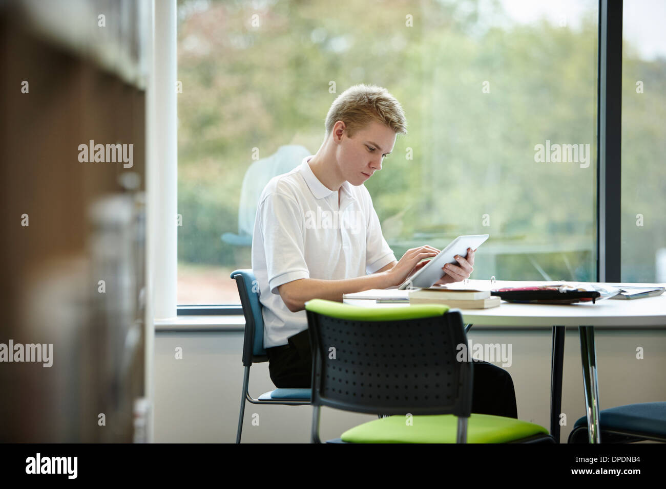 Teenager mit digital-Tablette in Bibliothek Stockfoto