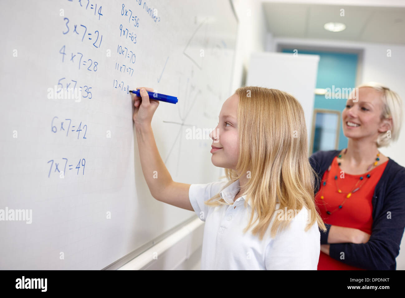 Schulmädchen tun Multiplikation auf Tafel Stockfoto