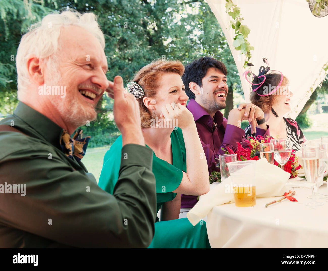 Frisch verheiratetes Paar mit Eltern bei Hochzeitsfeier Stockfoto