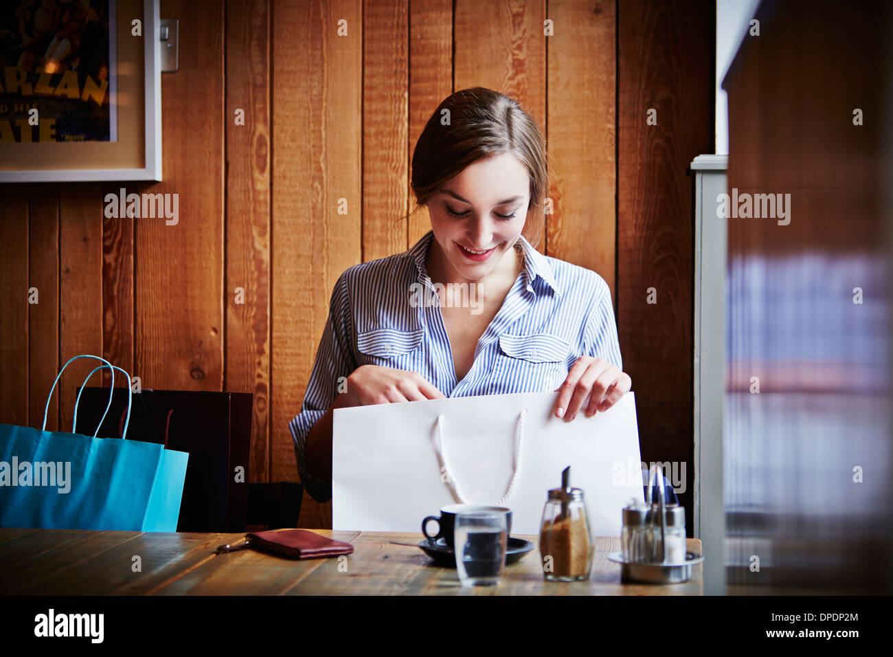 Junge Frau sitzt im Café suchen Warenkorb ist leer Stockfoto