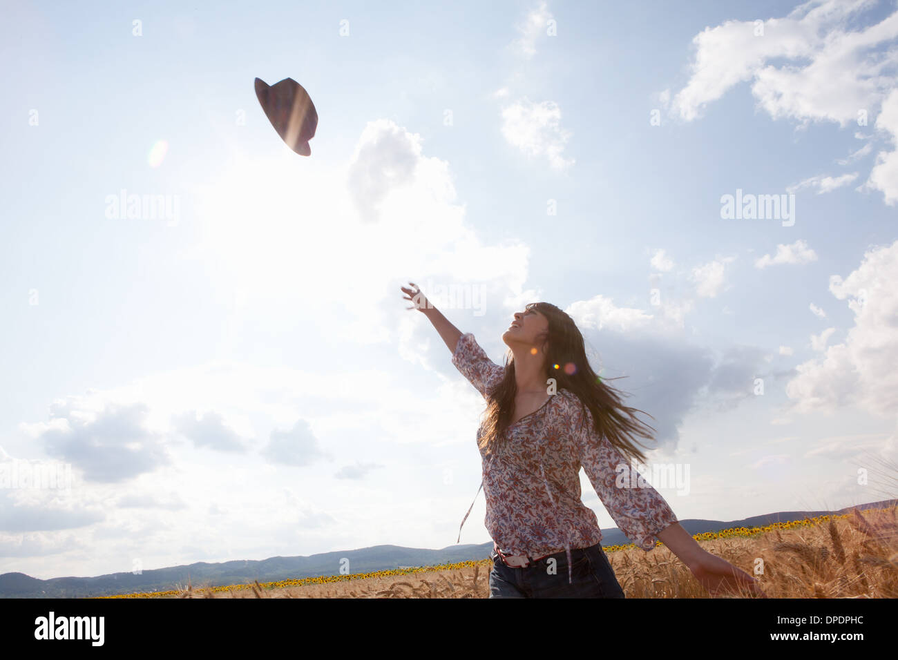 Mitte Erwachsene Frau werfen Hut in Luft Stockfoto