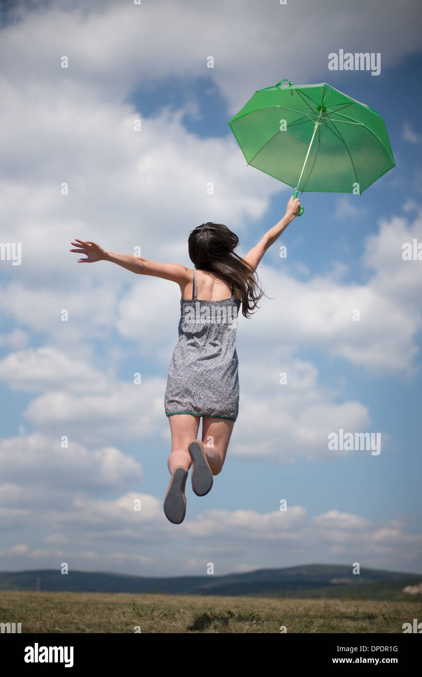 Mitte Erwachsene Frau mit grünen Dach springen Stockfoto