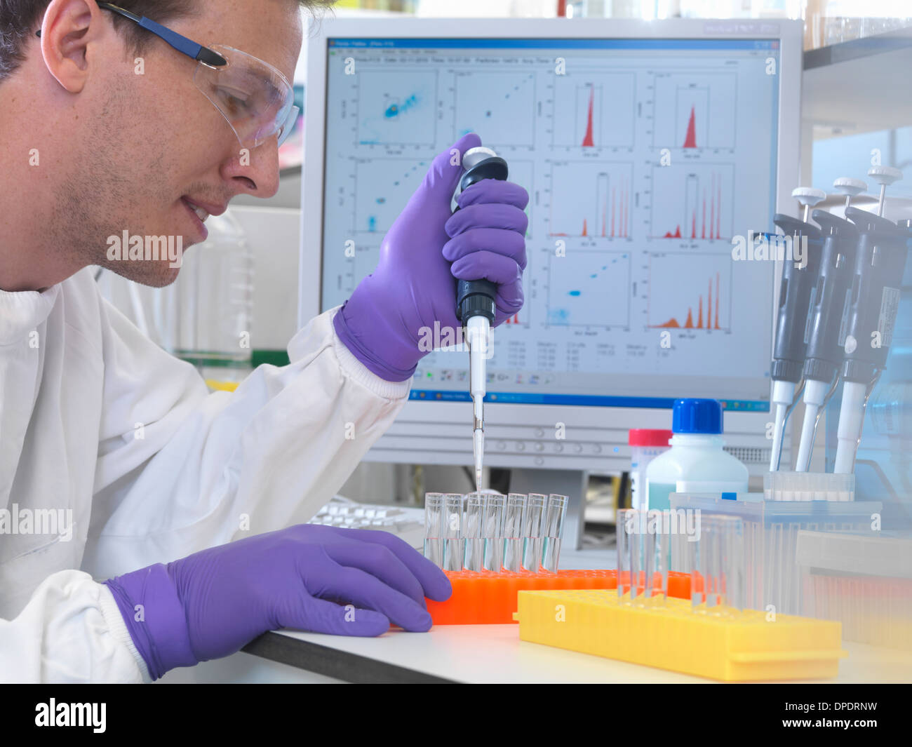 Männliche Wissenschaftler Pipettieren Probe in Reagenzgläser für Analyse der Zellpopulation Stockfoto