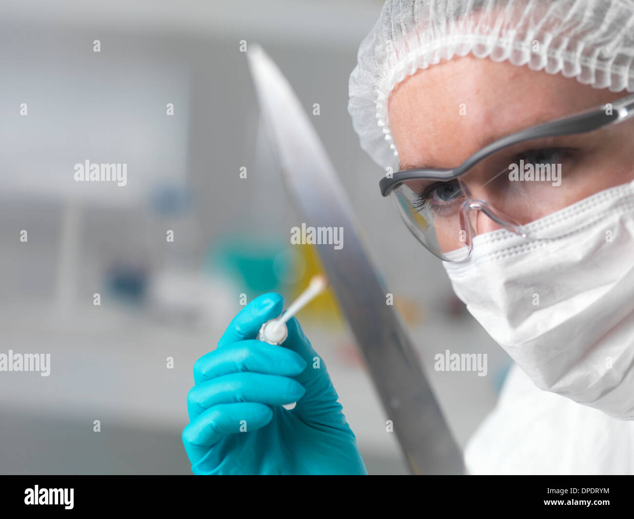 Forensische Wissenschaftler im Labor Beweisaufnahme DNA mit einem Tupfer für Verbrechensaufklärung Stockfoto