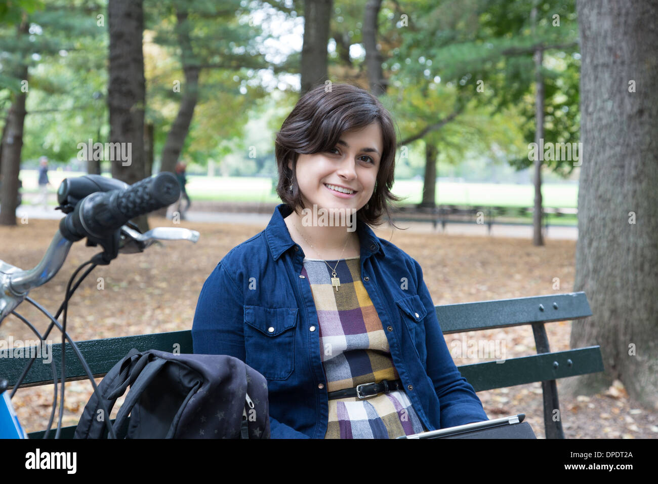 Junge Frau sitzt im Park mit digital-Tablette Stockfoto