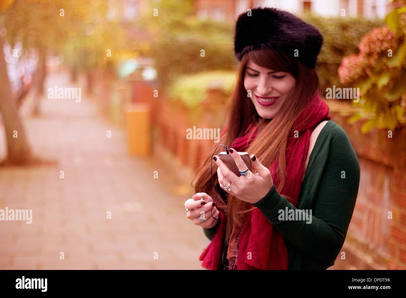 Junge Frau tragen Winterkleidung, mit smartphone Stockfoto
