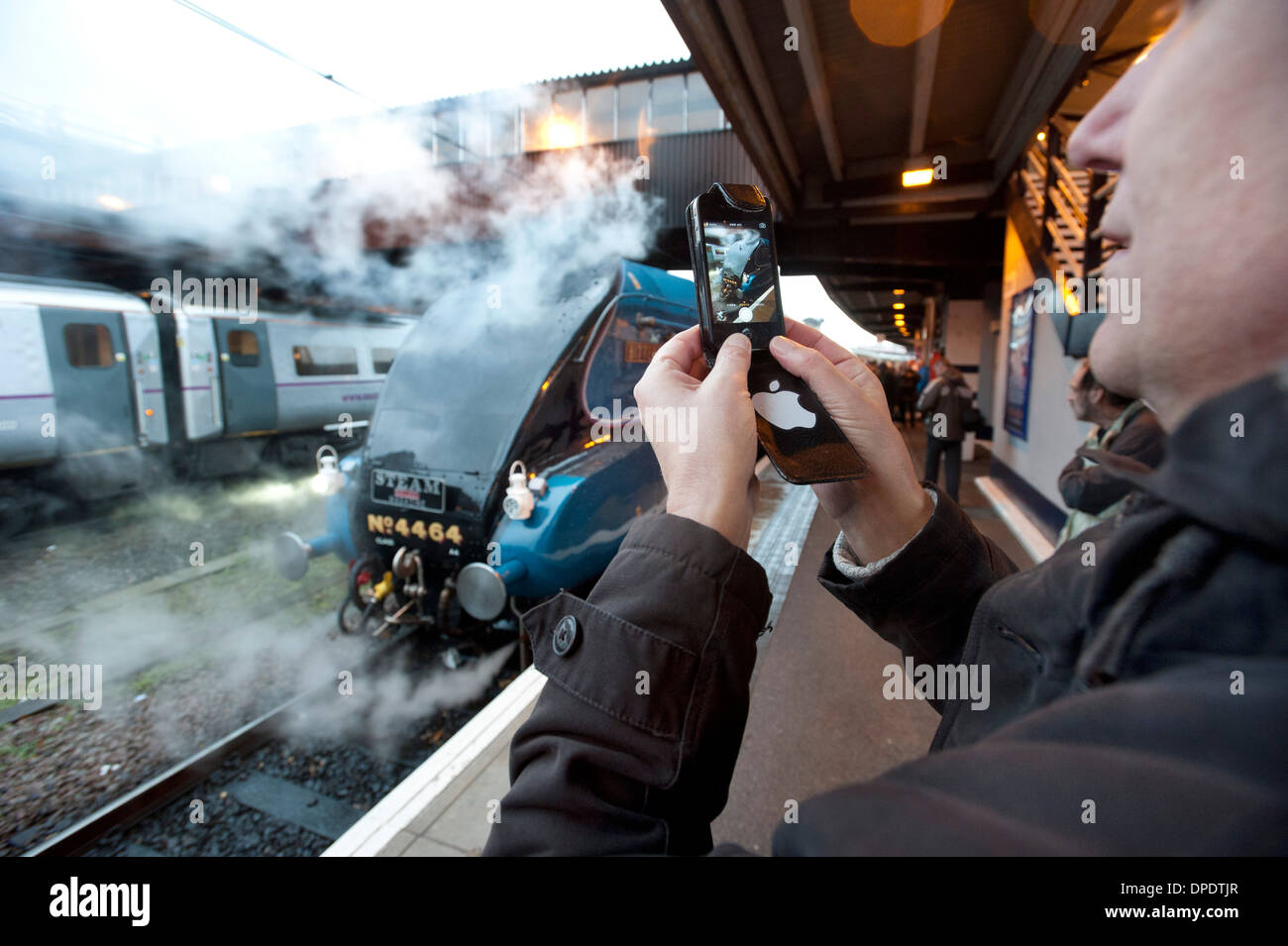 Mann mit Fotohandy, ein Bild von einer Dampfmaschine in York Station nehmen. Stockfoto