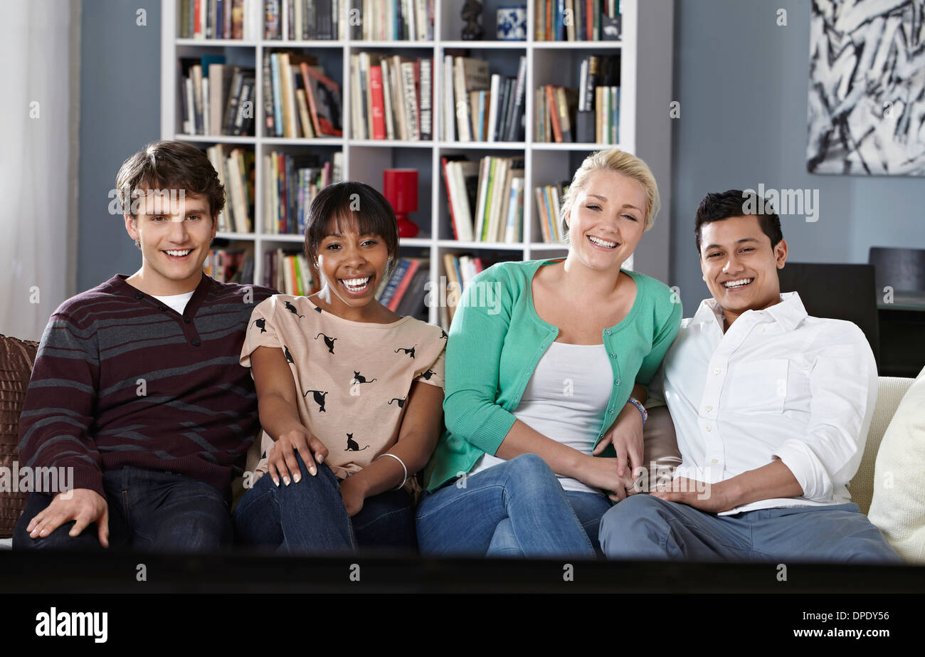 Junge Leute sitzen auf dem Sofa vor dem Fernseher Stockfoto