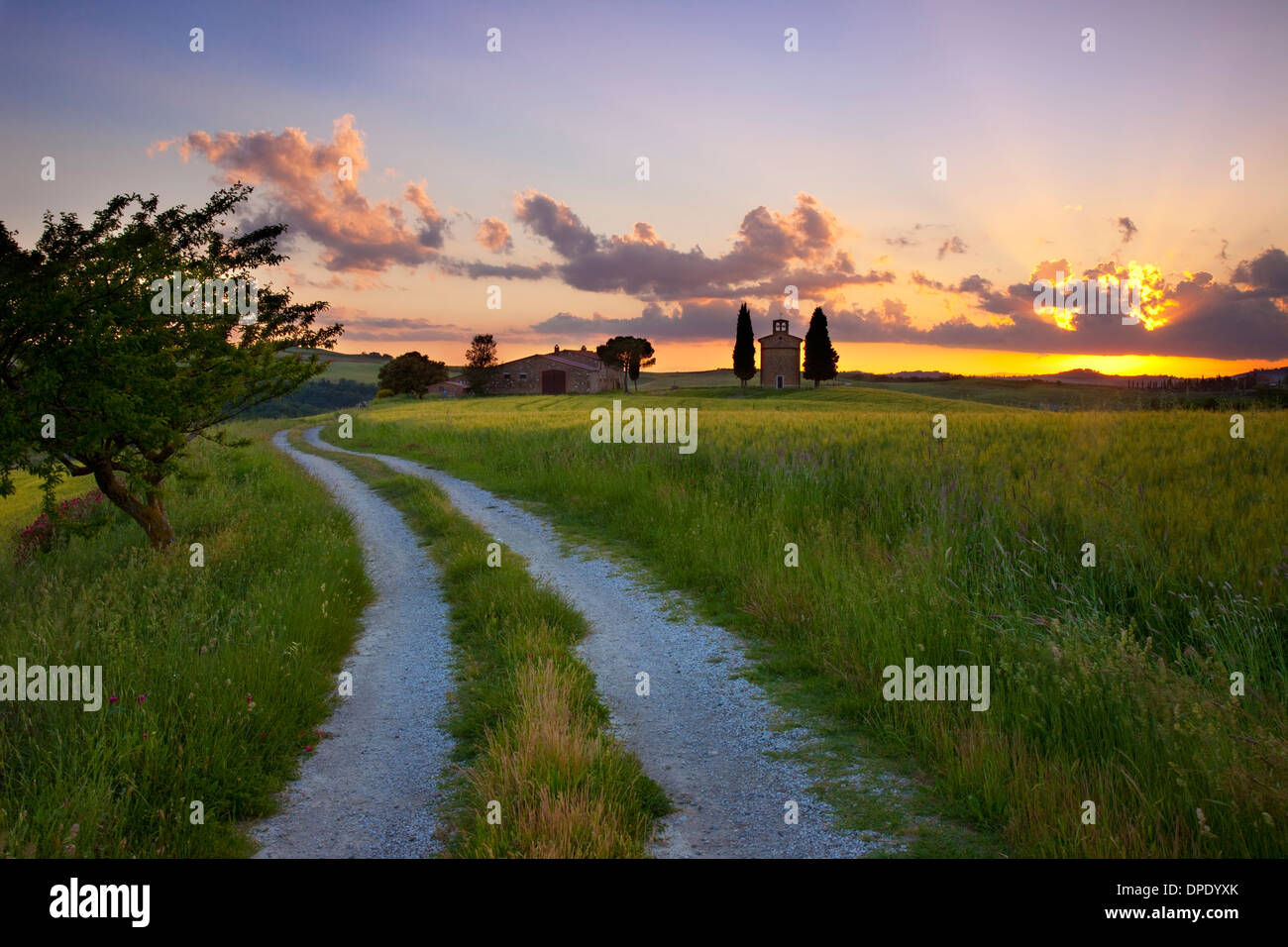 Feldweg führt zu Cappella di Vitaleta und die toskanische Landschaft bei Sonnenuntergang in der Nähe von San Quirico d'Orcia, Toskana, Italien Stockfoto
