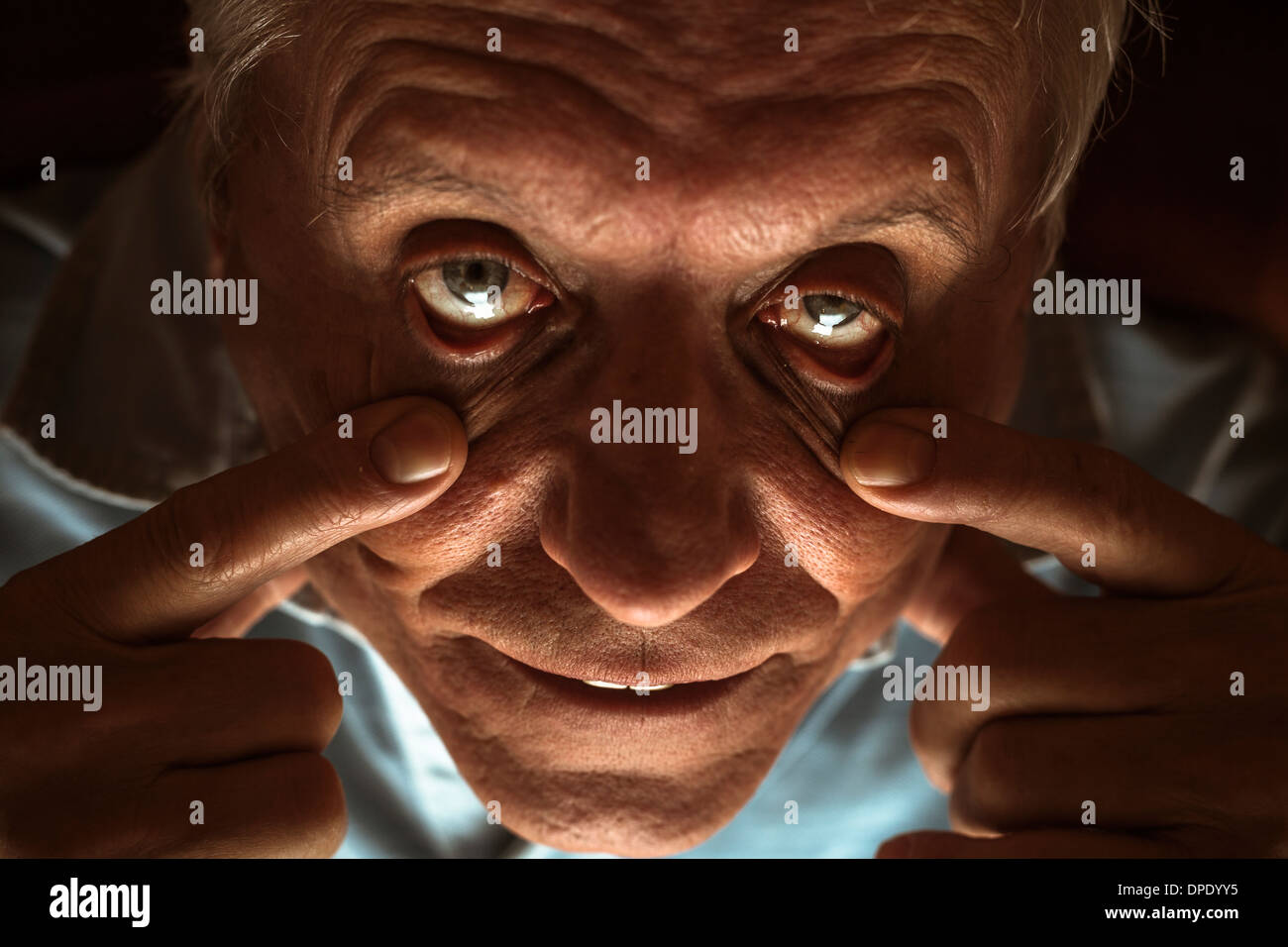 Nahaufnahme von beängstigend senior Mann zeigt seine Augen Stockfoto