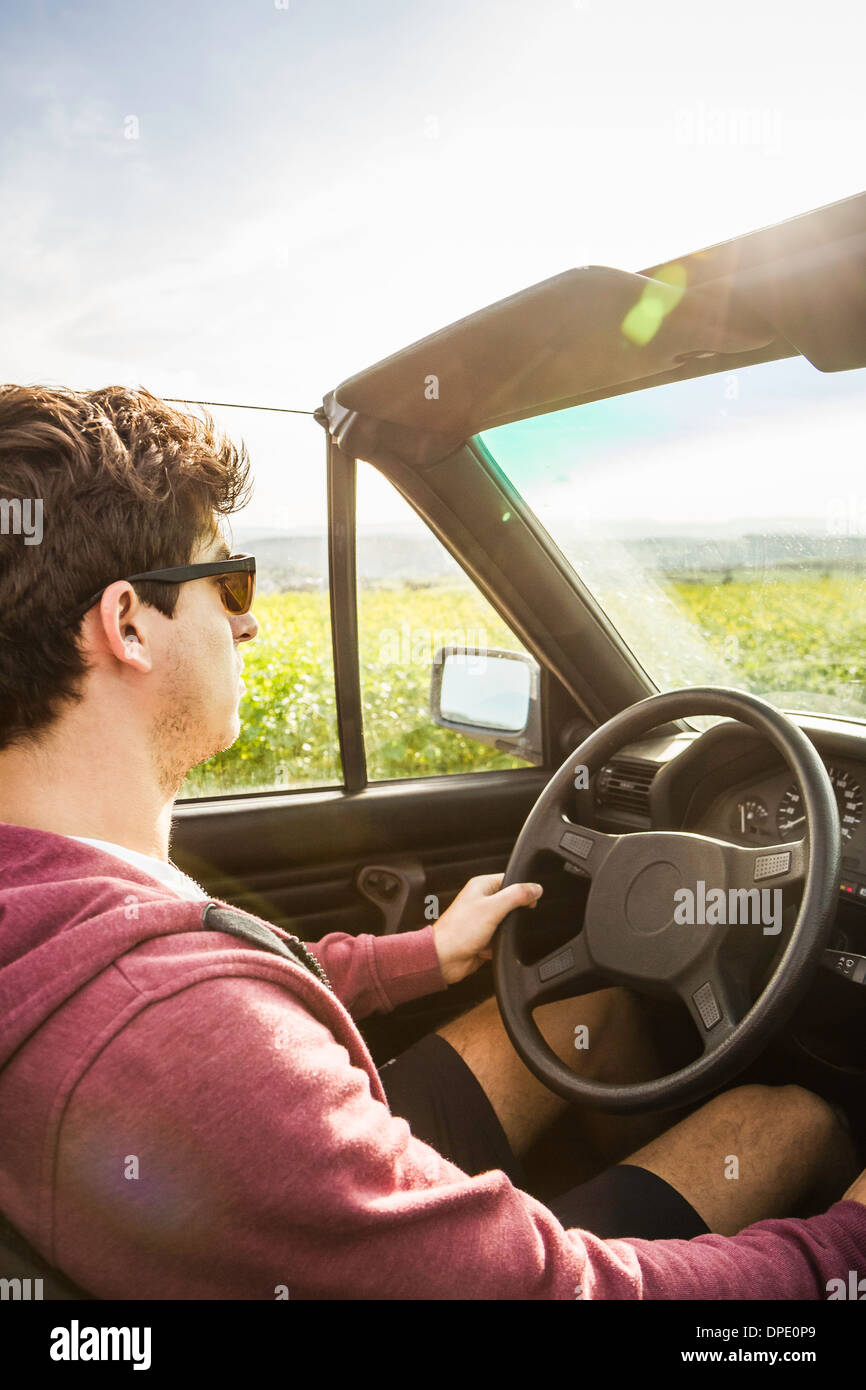 Junger Mann gelehnt, Cabrio fahren Stockfoto