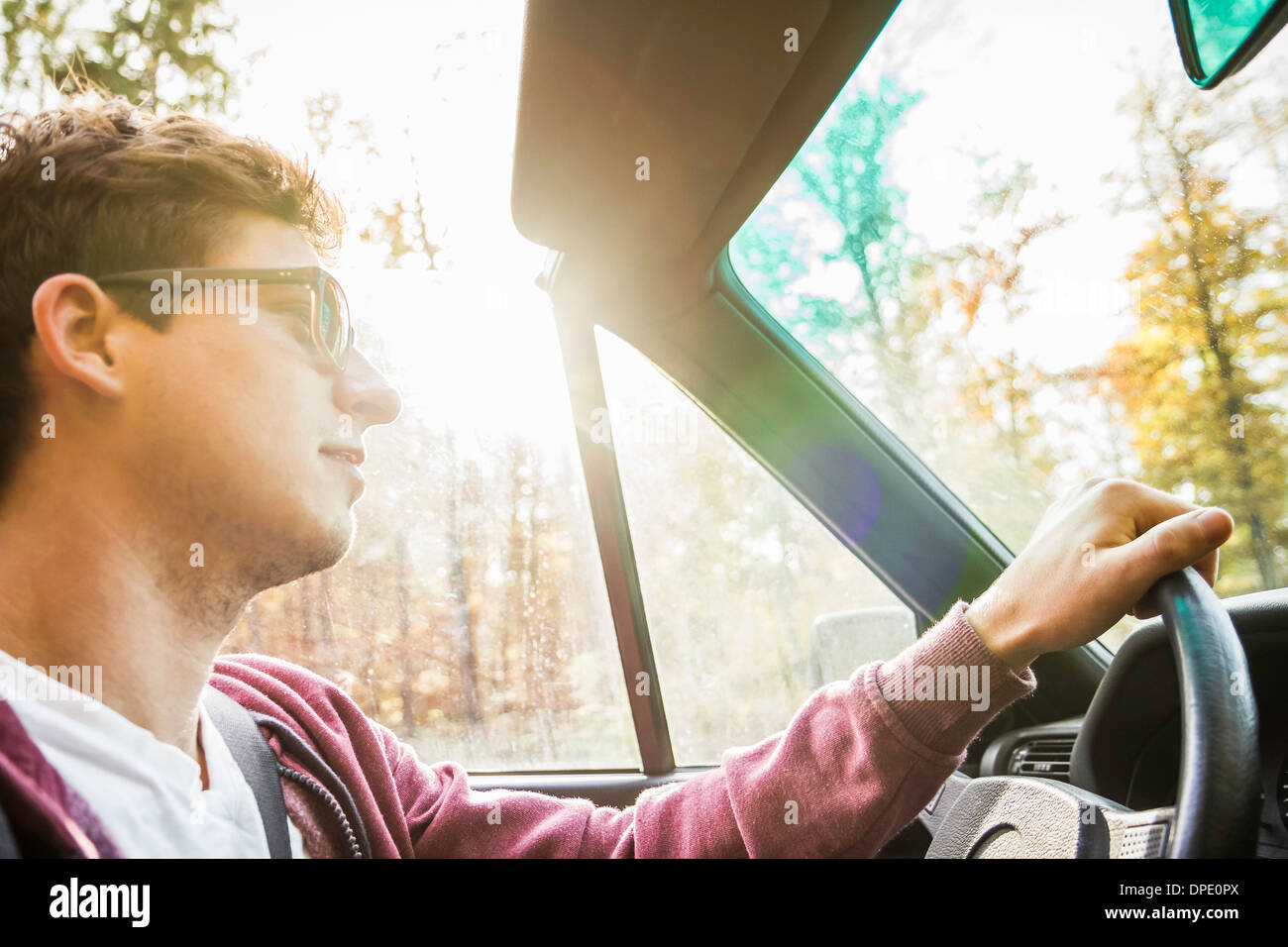 Junger Mann stützte sich auf Landstraße Cabrio fahren Stockfoto