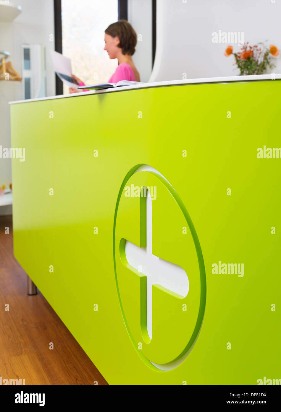 Medizinische Rezeption mit Frau arbeitet im Hintergrund Stockfoto