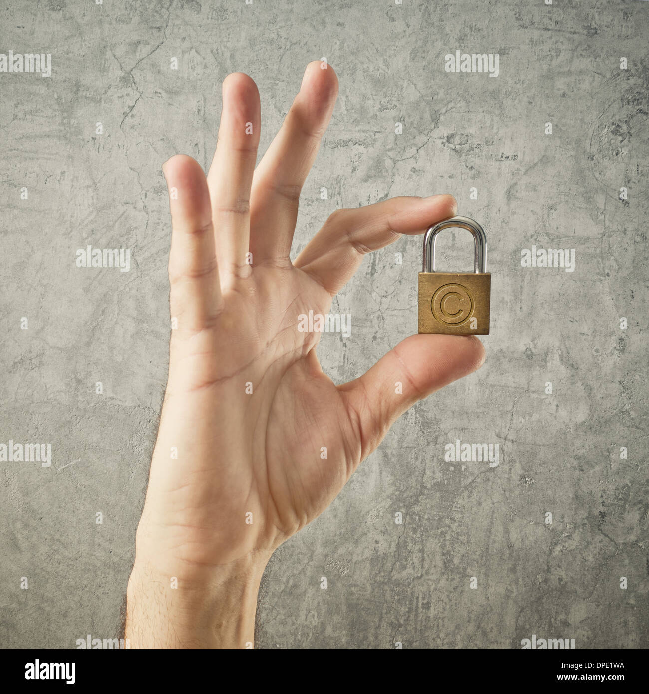 Hand mit Vorhängeschloss mit Copyright-Symbol. Sicherheit und Versicherung Konzept. Stockfoto