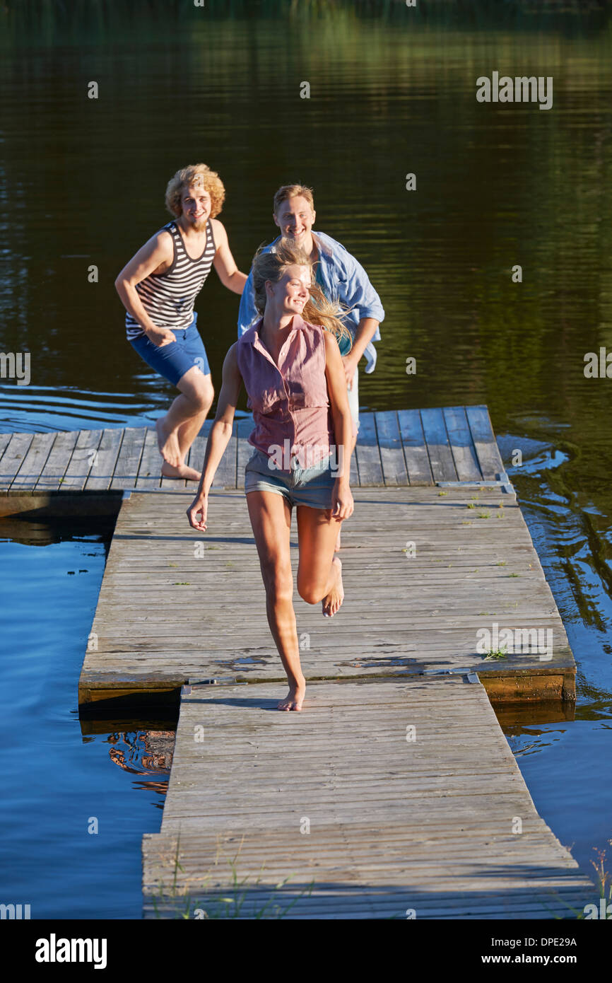Drei junge Erwachsene Freunde laufen auf Pier, Hotels, Schweden Stockfoto
