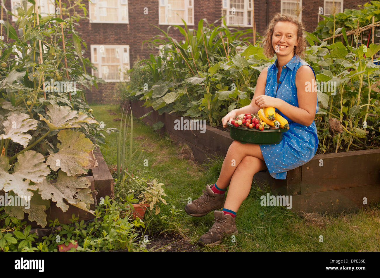 Junge Frau mit geernteten Gemüse auf Sozialsiedlung Zuteilung Stockfoto