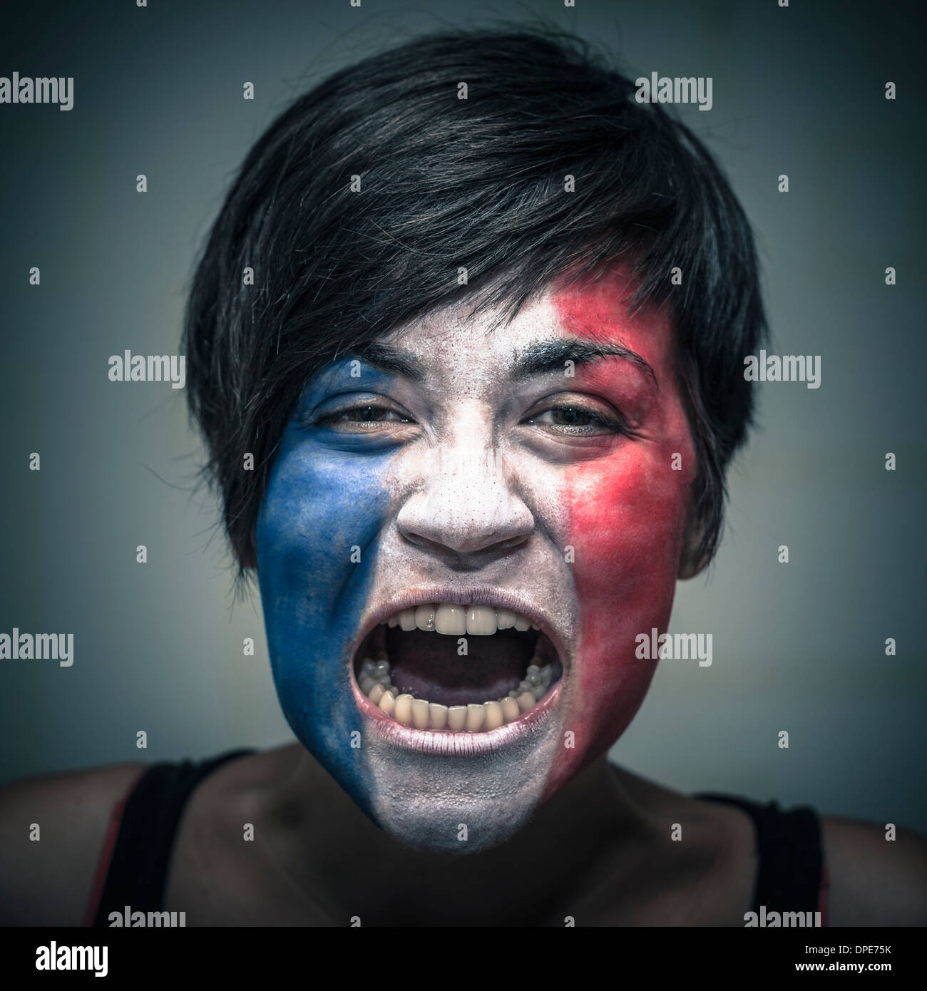 Porträt von wütenden Frau mit Flagge von Frankreich auf Gesicht gemalt. Stockfoto