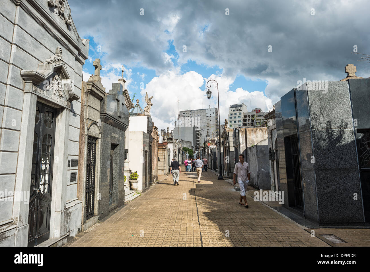 Recoleta Cemetery Pathway Buenos Aires Argentinien // BUENOS AIRES, Argentinien — Ein Pfad auf dem Recoleta Cemetery (Cementerio de la Recoleta) zeigt das städtische Layout des Friedhofs. Diese Fußgängerkorridore, die die Straßen der Stadt nachahmen, bilden ein organisiertes Gitter zwischen den kunstvollen Mausoleen und Gräbern. Die rationelle Planung des Friedhofs spiegelt den europäischen Einfluss auf die argentinische Stadtgestaltung des 19. Jahrhunderts wider. Stockfoto