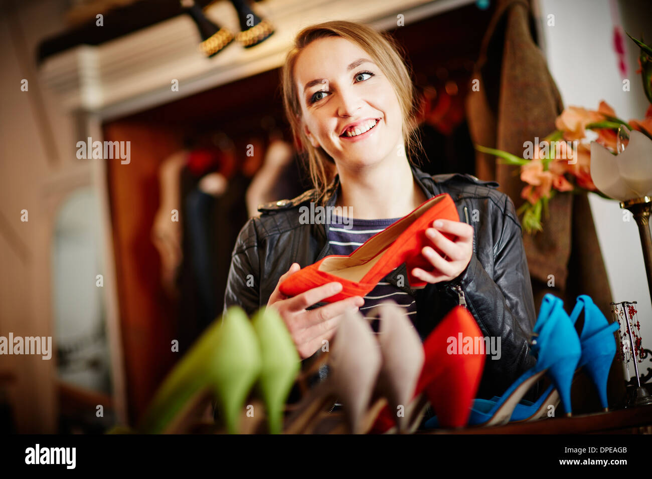 Junge Frau, die Auswahl an high Heels betrachten Stockfoto