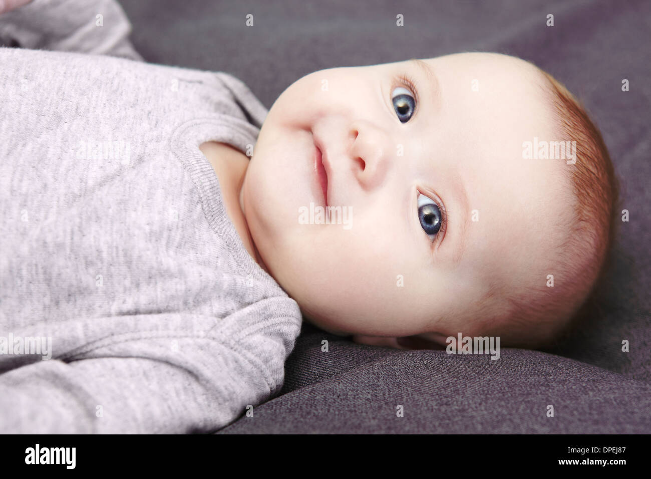 Studioportrait von lächelndes Babymädchen auf Rücken liegend Stockfoto