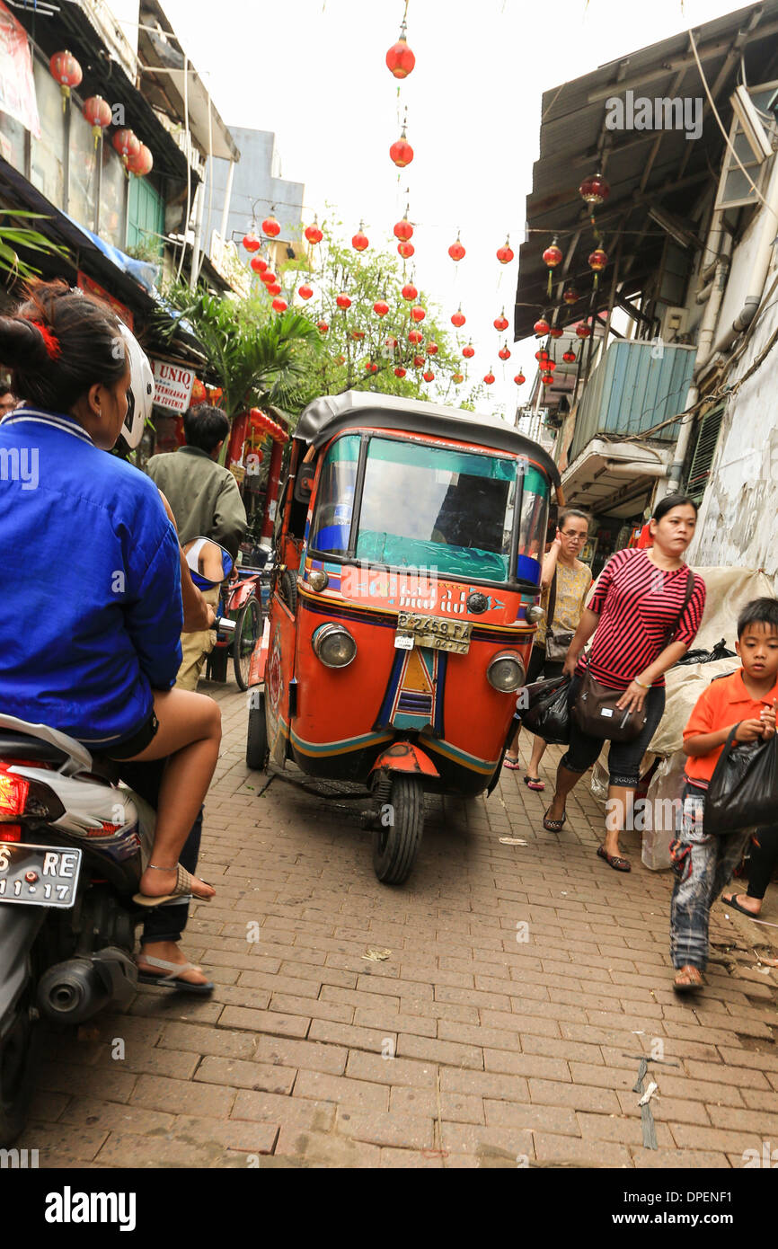 Ein Bajaj (Tuk Tuk) fahren in einer kleinen Straße in Jakarta Chinatown, bekannt als Glodok, Indonesien. Jakarta ist eine sehr dicht besiedelte Stadt Stockfoto