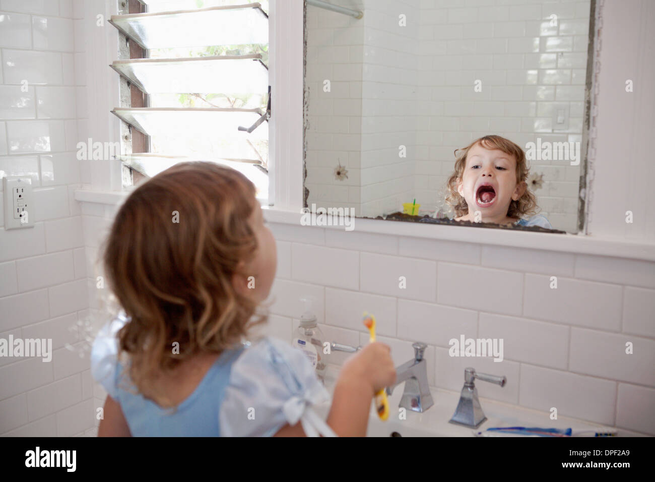 Weiblichen Kleinkind in Spiegel Zahnreinigung Stockfoto