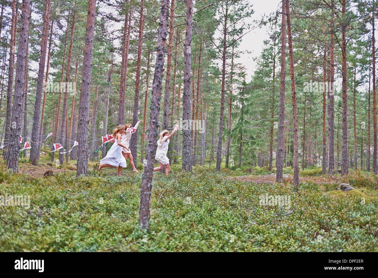 Mädchen im Teenageralter in Wald mit Drachen laufen Stockfoto
