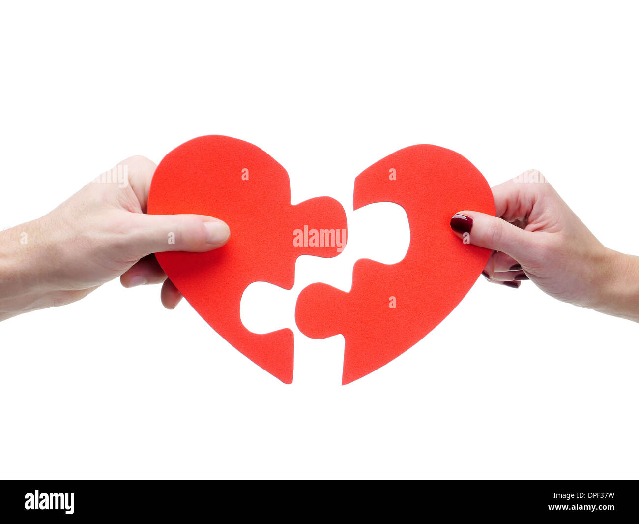 Männliche und weibliche hand passenden roten Puzzle Herzhälften auf weißem Hintergrund Stockfoto