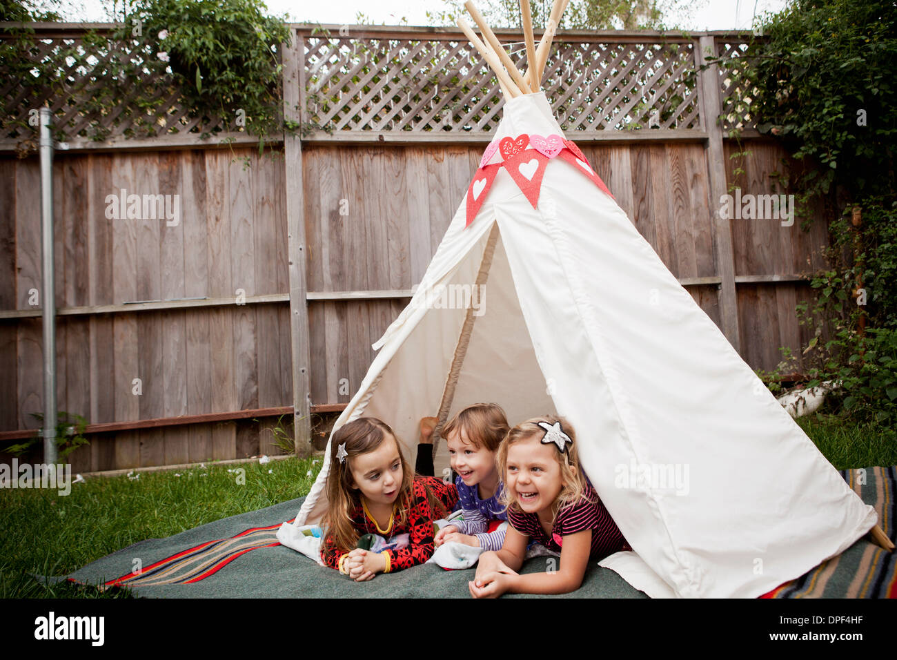 Drei junge Mädchen im Tipi im Garten liegen Stockfoto