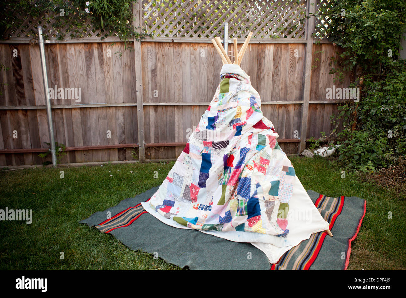 Tipi, eingewickelt in eine Decke im Garten Stockfoto
