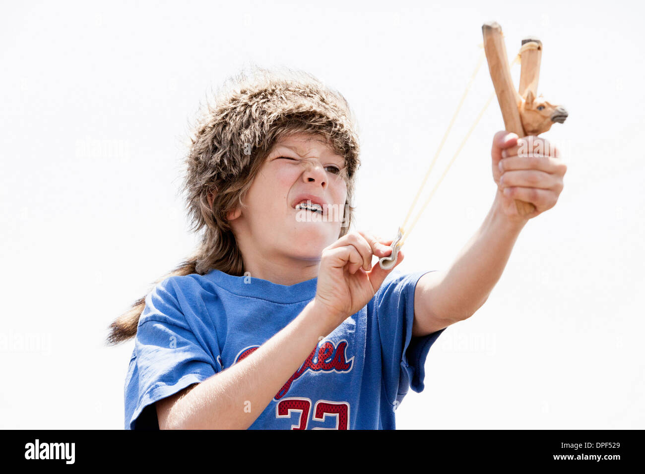 Junge Trapper Hut mit Sling shot spielen Stockfoto