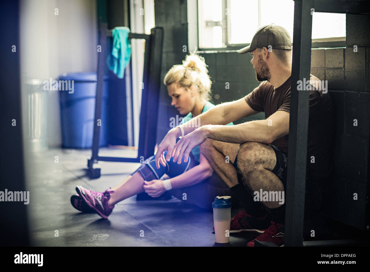 Trainer im Gespräch mit junge Frau im gymnasium Stockfoto