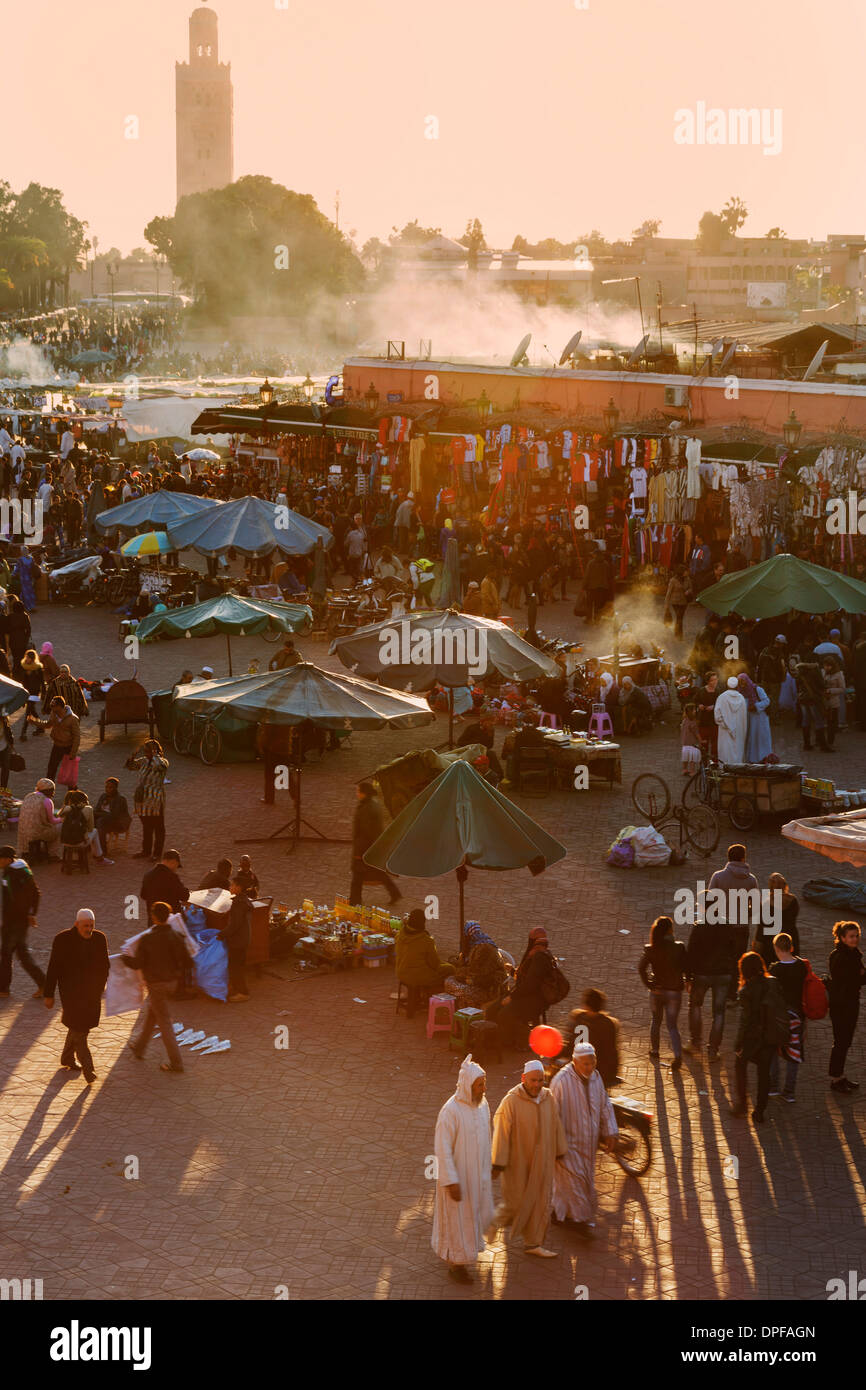 Die belebten Platz der Platz Djemaa el-Fna mit das Minarett der Koutoubia-Moschee in der Ferne, der UNESCO, Marrakesch, Marokko Stockfoto