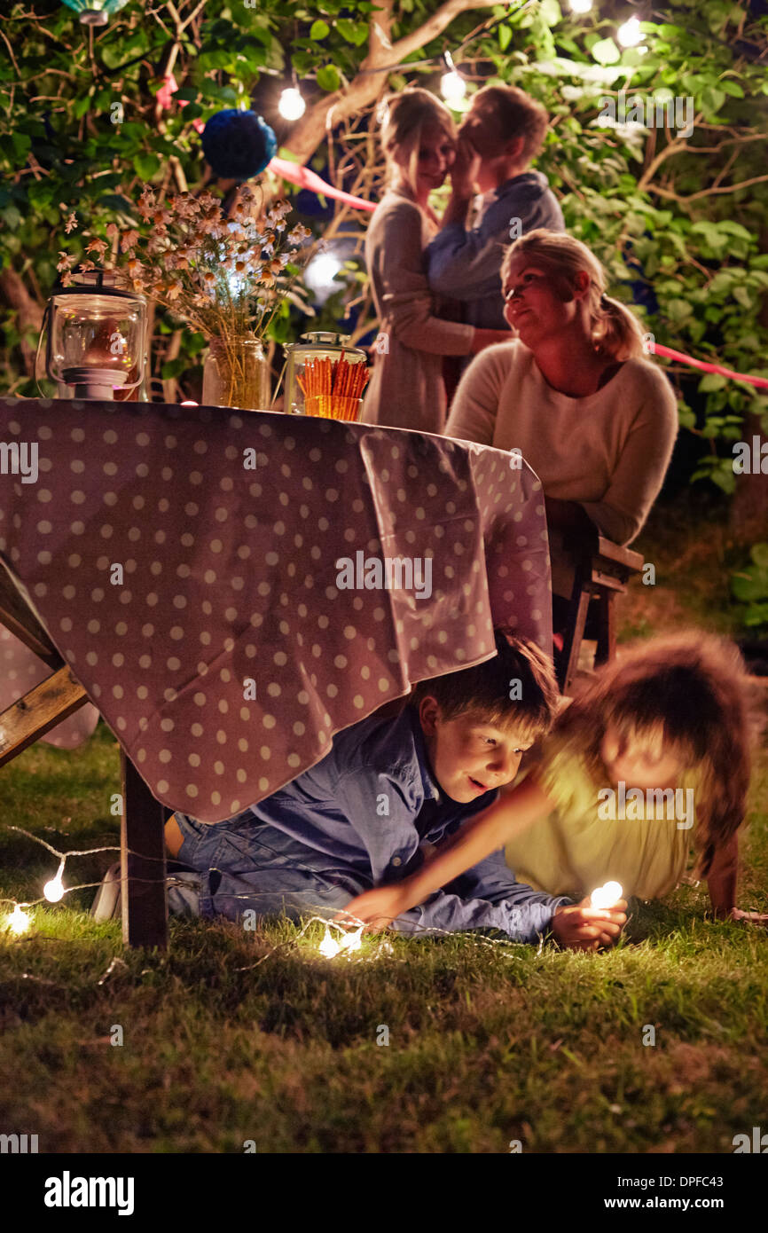 Schelmische Kinder Garten-Party in der Nacht genießen Stockfoto