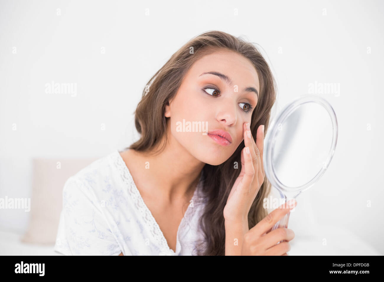 Attraktive Brünette, die eng mit Blick auf Spiegel Stockfoto