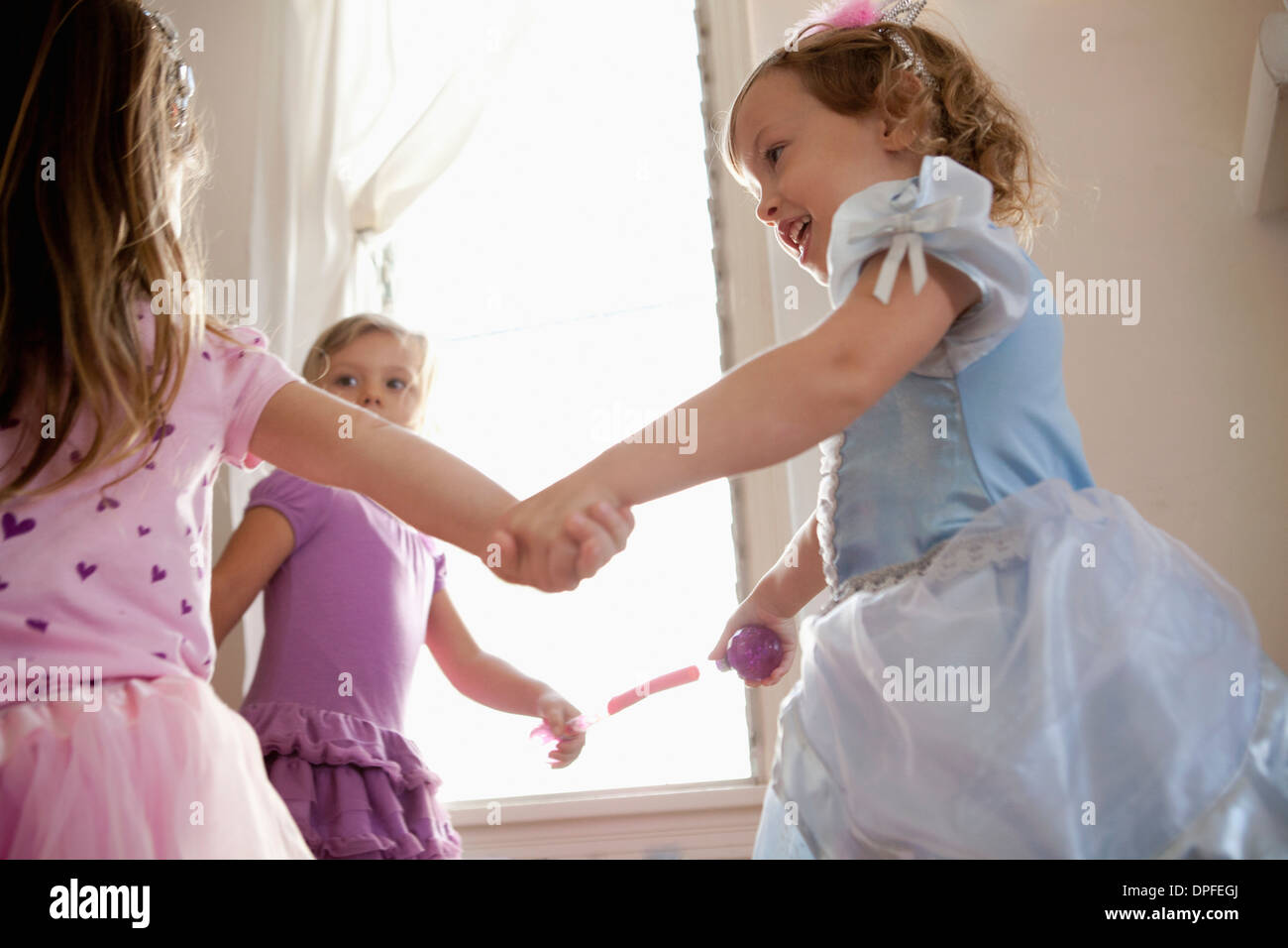 Drei junge Mädchen im Festkleid Hand in Hand und tanzen Stockfoto