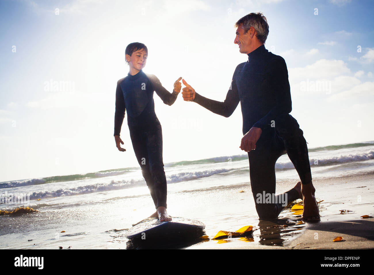 Vater und Sohn mit Surfbrett am Strand, Encinitas, Kalifornien, USA Stockfoto