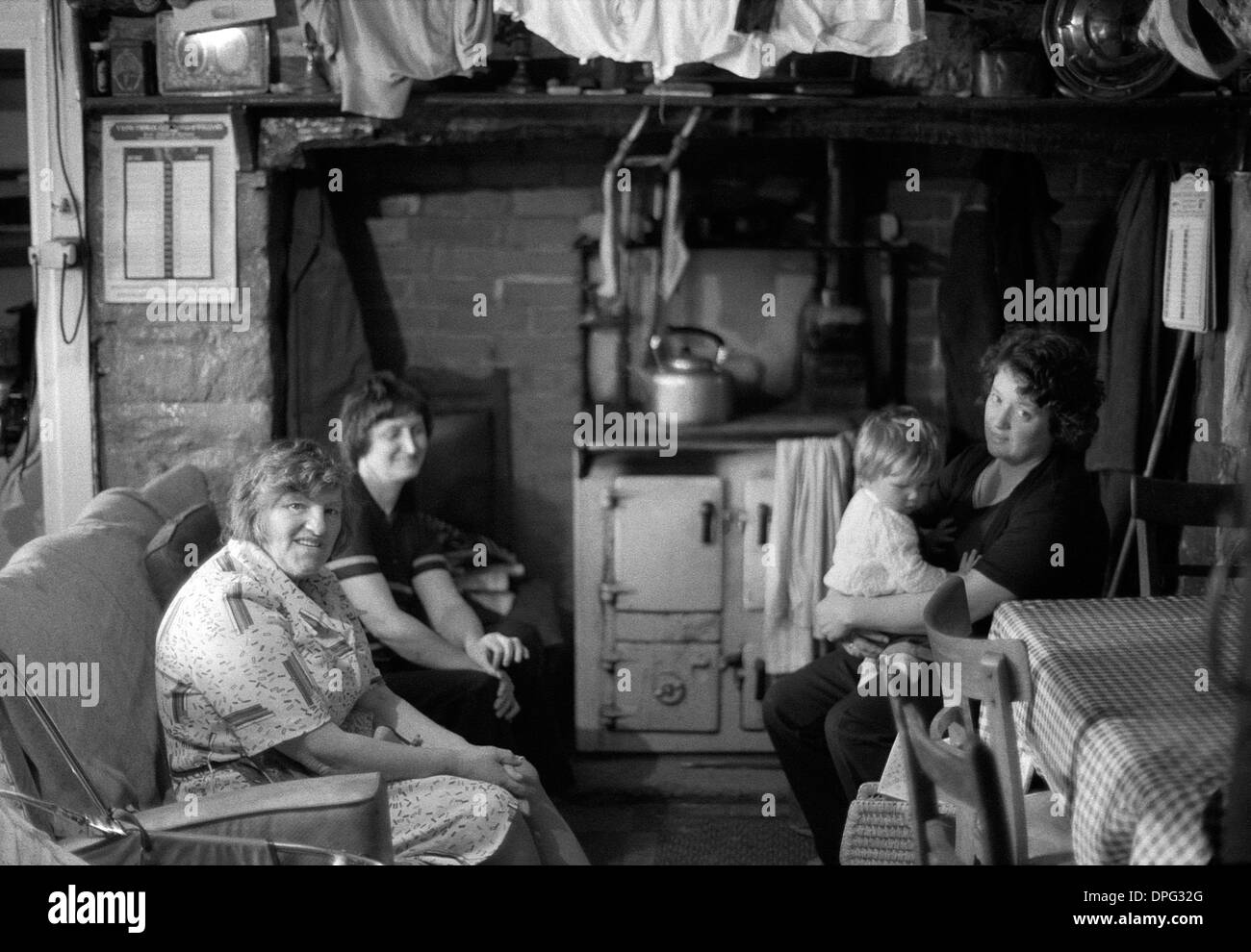 Walisische Frauenfamilie mit Kind sitzt zusammen von der rayburn Herd in einer Küche bei Scheren Zeit bereit für Schafe Scherer kommen zum Abendessen in Carmarthenshire Wales UK KATHY DEWITT Stockfoto