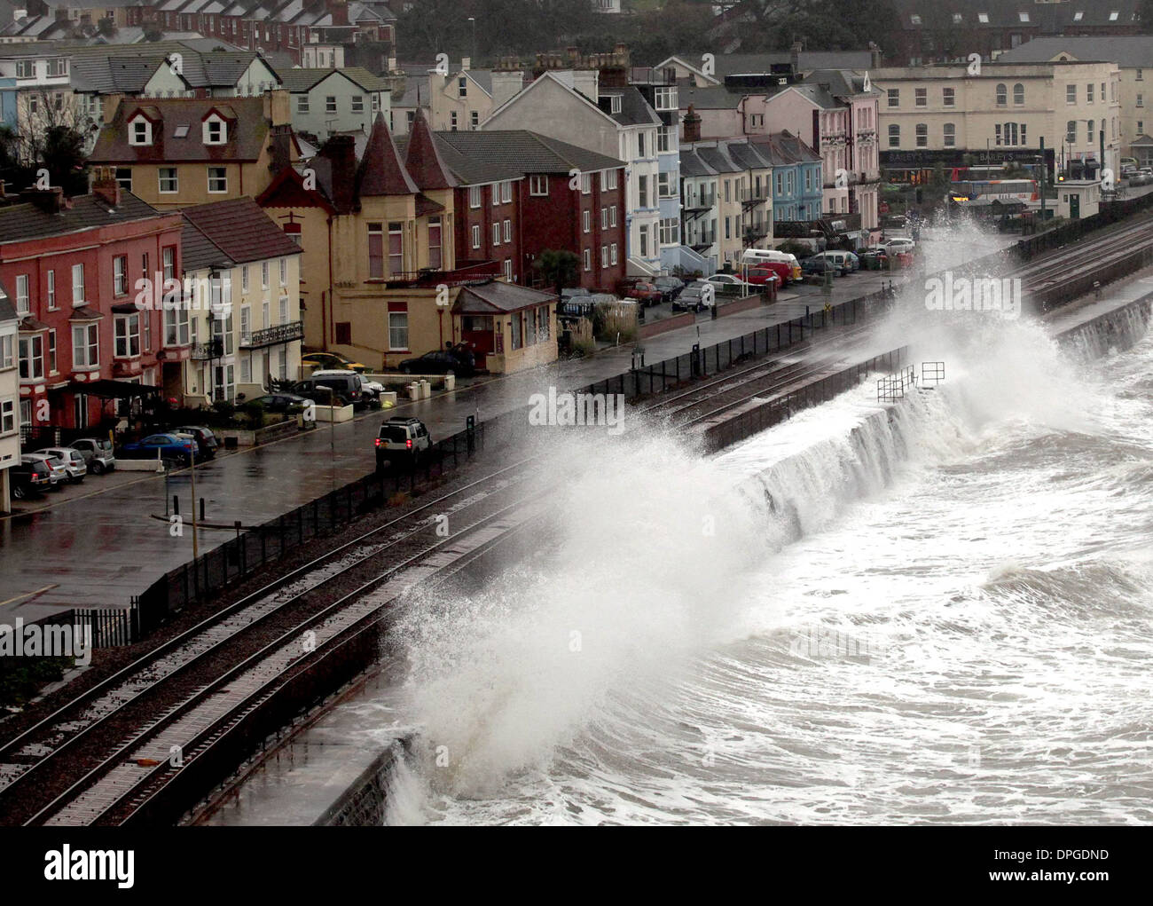 Ein Zug wird durch Wellen zerschlagen, passieren den Bahnhof Dawlish, Devon Stockfoto