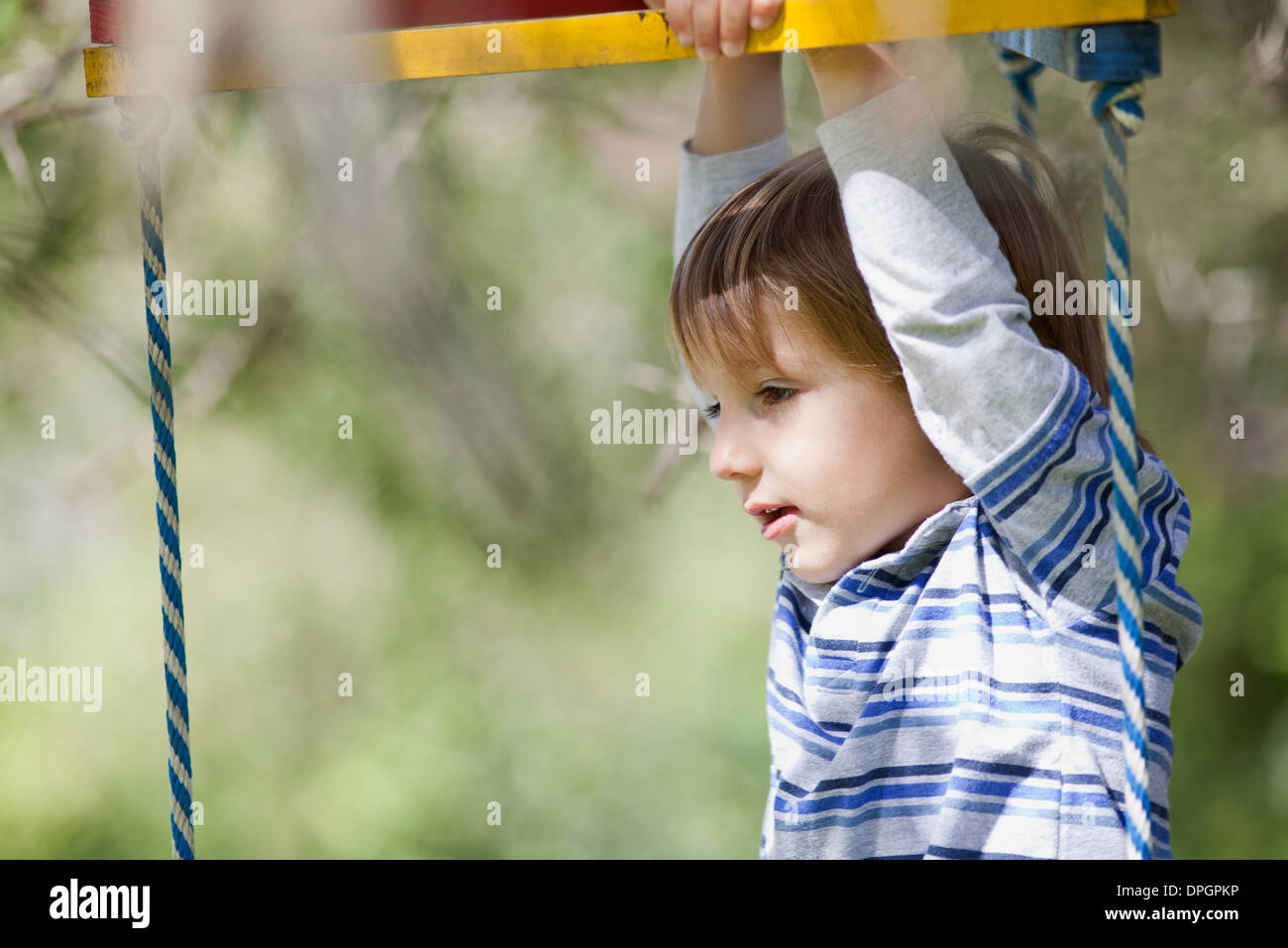 Junge spielt auf Klettergerüst Stockfoto