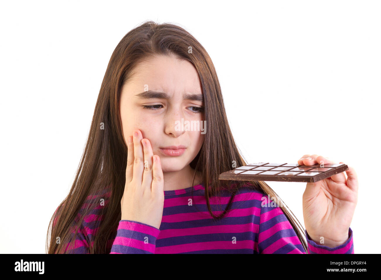 Mädchen mit Zahnschmerzen weil sie Schokolade isst Stockfoto