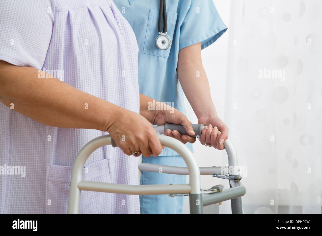 Krankenschwester hilft senior Frau mit Walker, Nahaufnahme Stockfoto