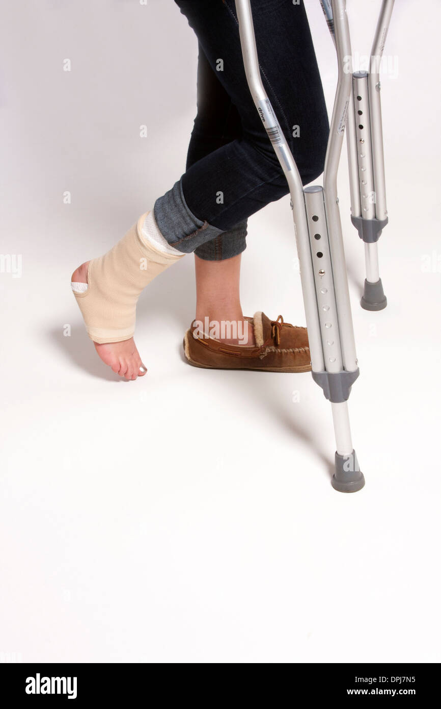 Ein Mädchen mit einem verletzten Fuß auf Krücken Stockfoto
