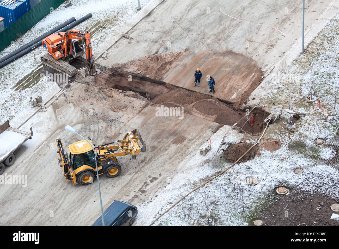Arbeiten Sie mit der Überarbeitung der Heizung auf der anderen Straßenseite. Auffüllen der Gräben mit Sand von Traktor. Russland Stockfoto