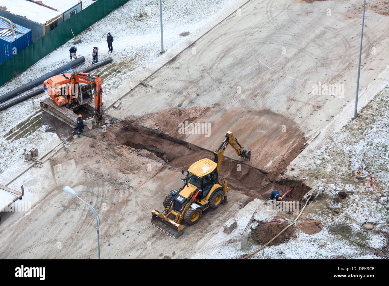 Arbeiten Sie mit der Überarbeitung der Heizung auf der anderen Straßenseite. Auffüllen der Gräben mit Sand von Traktor. Russland Stockfoto