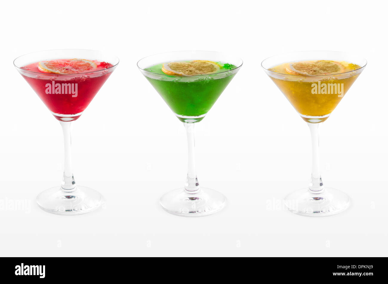 Rote, grüne und gelbe Cocktails mit einer Zitronenscheibe isoliert auf weißem Hintergrund Stockfoto
