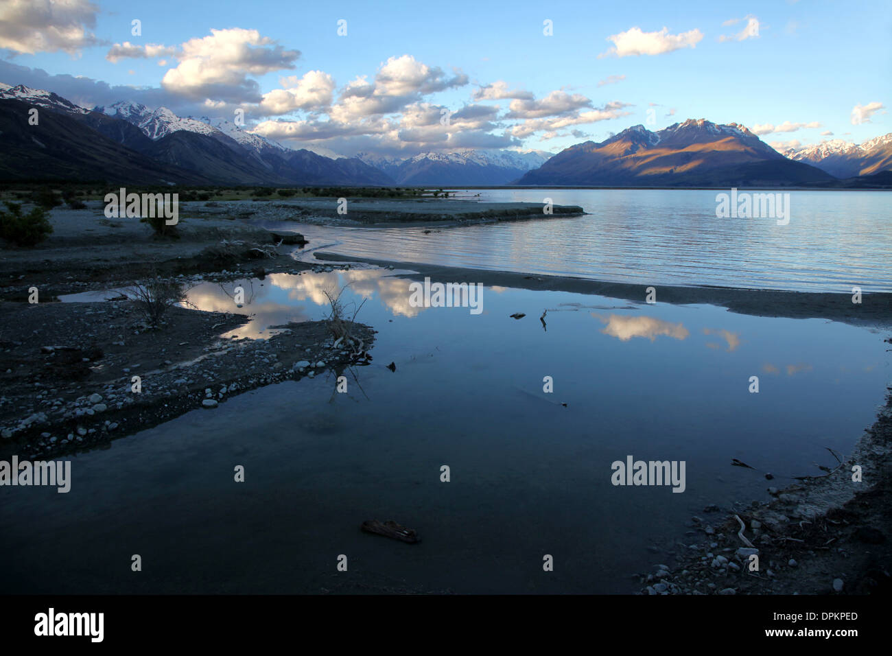 Lake Pukaki im Vordergrund spiegelt den Abendhimmel mit den Bergen des Bereichs Cook im Hintergrund Stockfoto